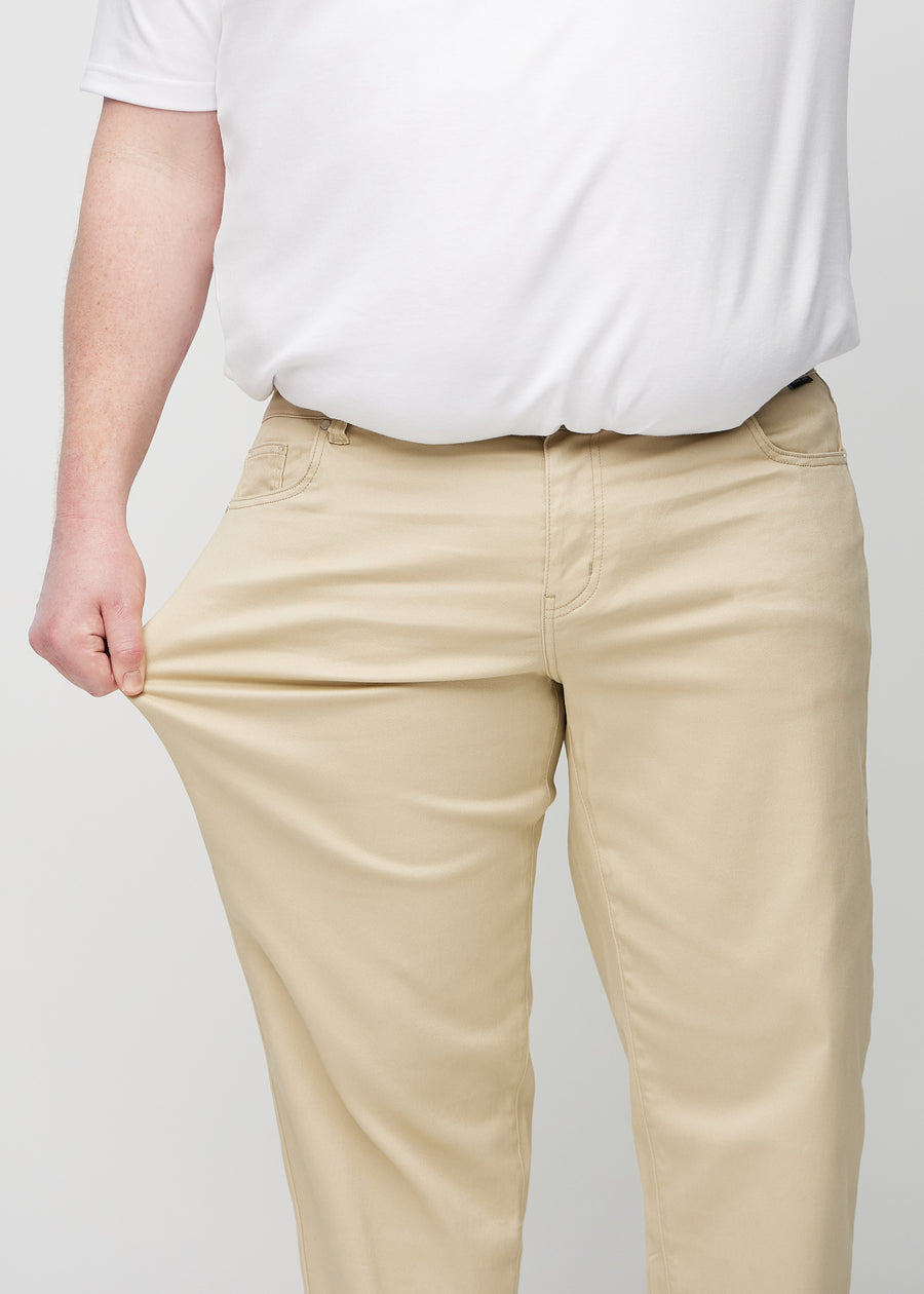 Das Plus-Size-Model dehnt die Jeans am Oberschenkel, um den Stretch zu zeigen.