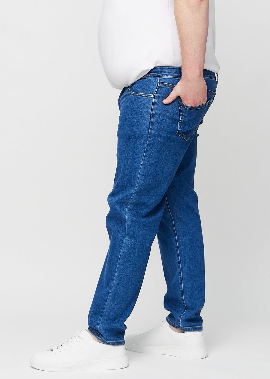 Dunkelblauer Denim regular jeans seitlich an einem Plus-Size-Model gesehen.