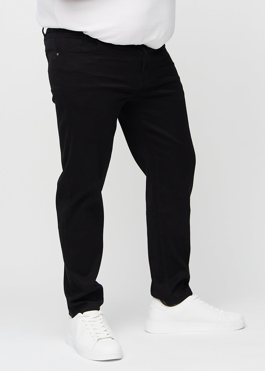 Schwarze regular jeans, Modellname Ravens, die gerade am Bein herunterfallen, an einem Plus-Size-Model von vorne gesehen.
