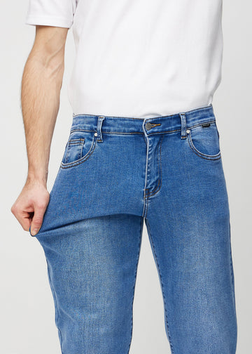 Das Model dehnt die Jeans am Oberschenkel, um den Stretch zu zeigen.