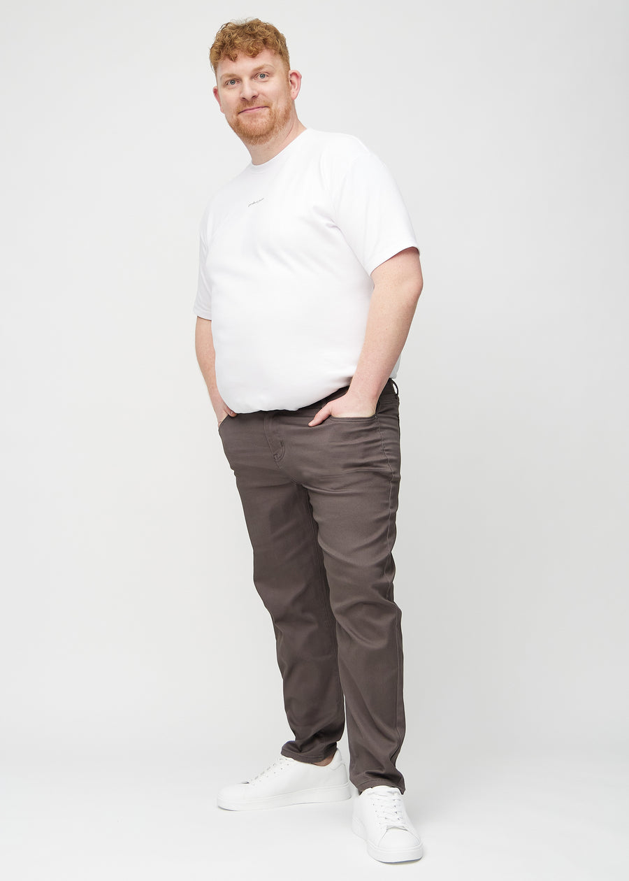 Ganzkörperbild eines Plus-Size-Models in graubraunen regular jeans.