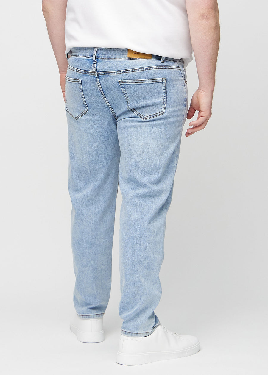 Heller Denim regular jeans von hinten an einem Plus-Size-Model gesehen, sodass man das gesamte Produkt sehen kann.