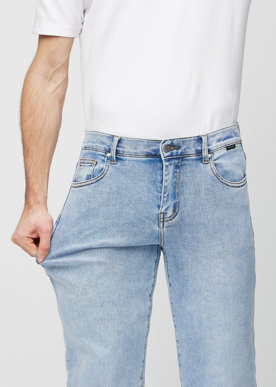 Das Model dehnt die Jeans am Oberschenkel, um den Stretch zu zeigen.