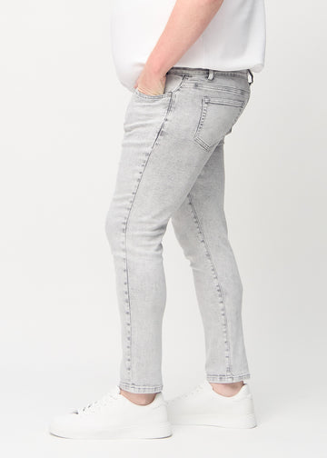 Hellgraue Denim-Jeans im Slim Fit, von der Seite an einem Plus-Size-Model gesehen.