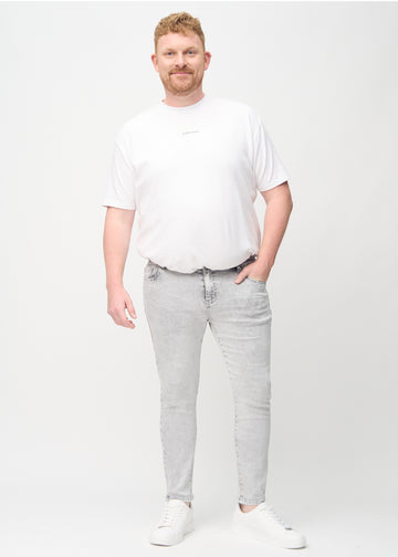 Ganzkörperaufnahme eines Plus-Size-Models in hellgraue Denim-Jeans im Slim Fit.