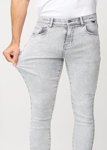 Ein Model dehnt die Jeans am Oberschenkel, um den Stretch des Materials zu zeigen.