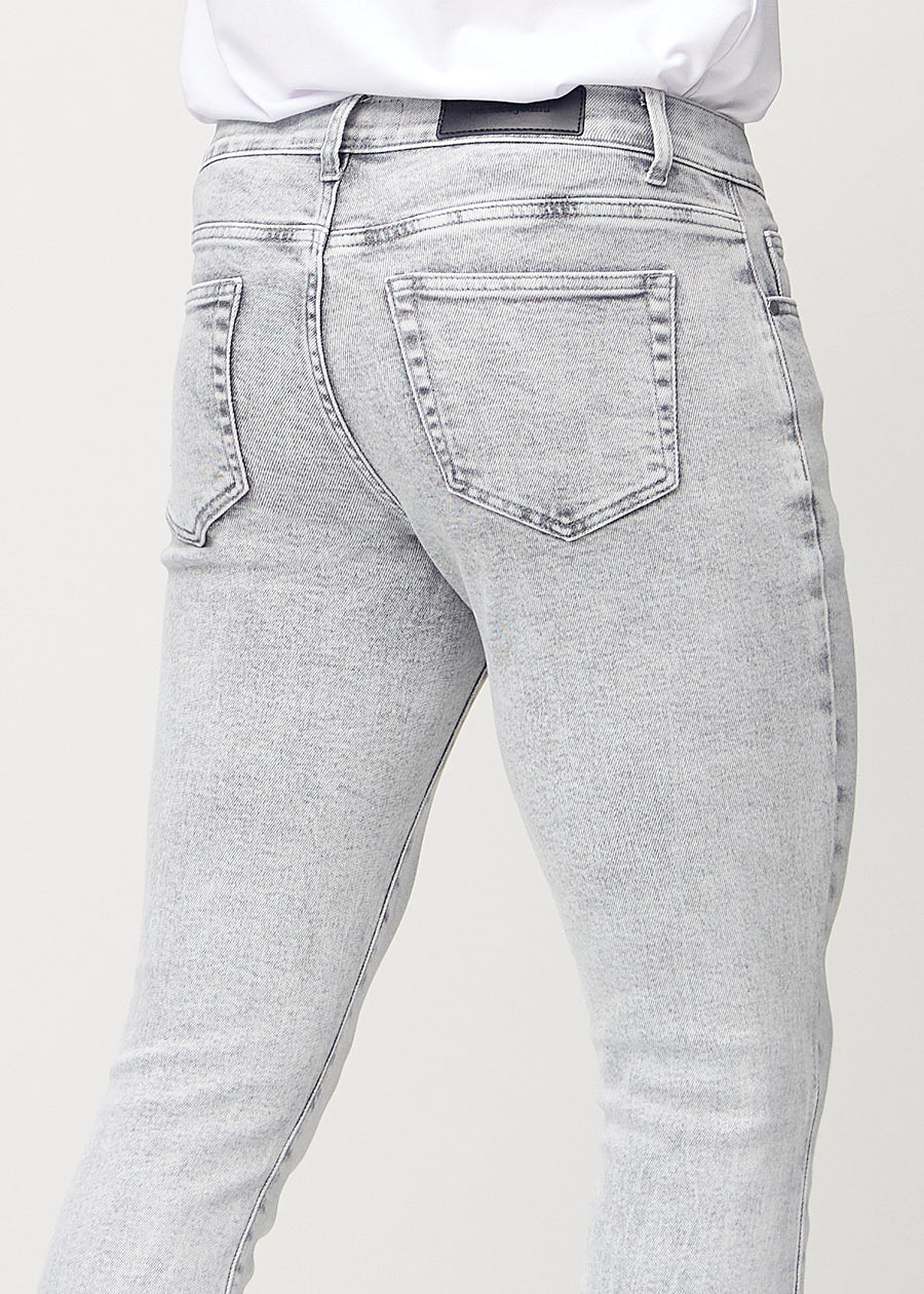 Nahaufnahme von hinten von hellgraue Denim-Jeans im Slim Fit, die Details zeigt.