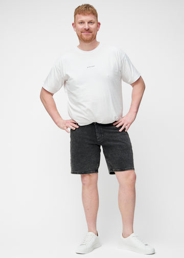 Ganzkörperbild eines Plus-Size-Modells in dunkelgrauen Denim-Shorts für Herren in der Farbe Shadows mit Regular-Passform.