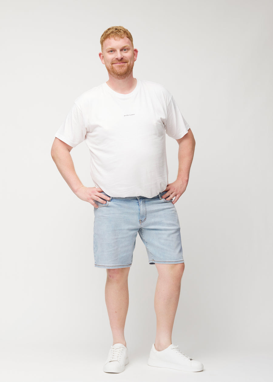 Ganzkörperbild eines Plus-Size-Models in hellblauen Denim-Shorts für Herren in der Farbe Waves mit regular Passform.