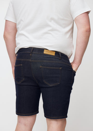 Tief dunkelblaue Denim-Shorts für Herren in der Farbe Midnights von hinten nah auf einem Plus-Size-Model aufgenommen.