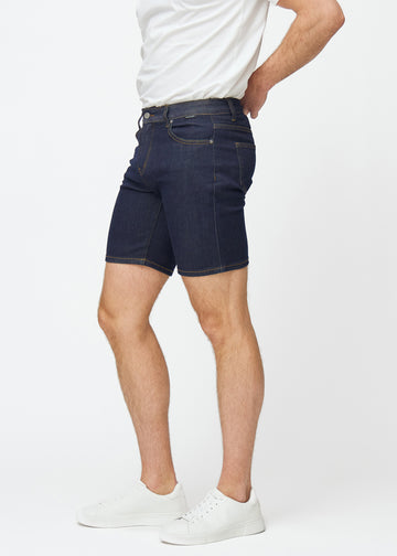 Tief dunkelblaue Denim-Shorts für Herren in der Farbe Midnights mit Slim-Passform, von der Seite am Model gesehen.