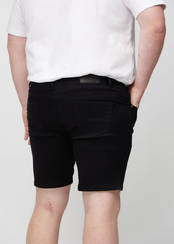 Schwarze middle-slim Shorts von hinten in der Nahaufnahme an einem Plus-Size-Model, um Details zu zeigen.