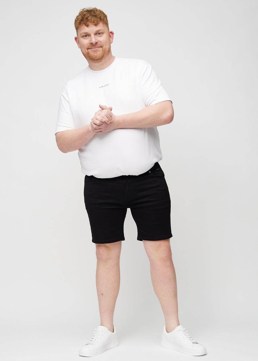 Ganzkörperbild eines Plus-Size-Models in schwarzen middle-slim Shorts.