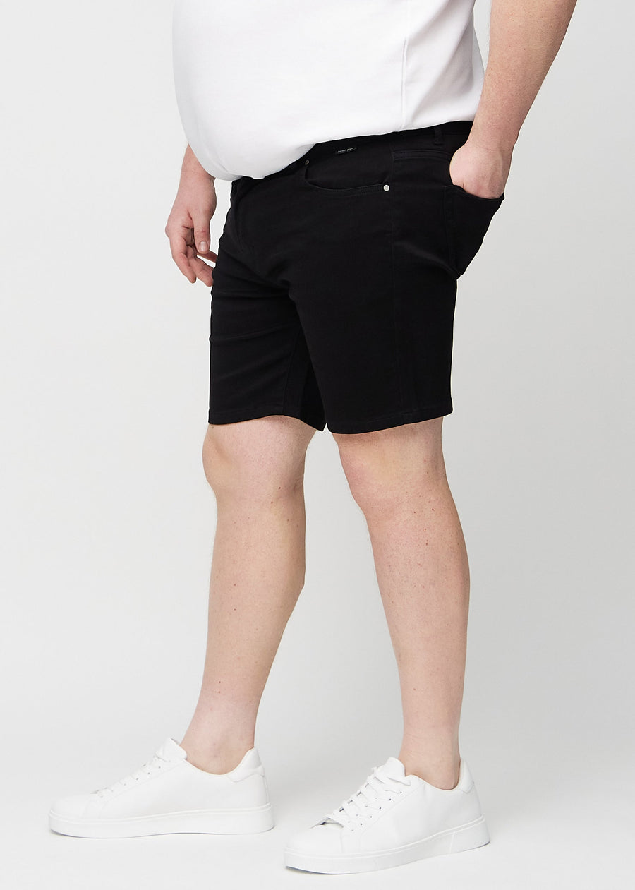 Schwarze middle-slim Shorts von der Seite an einem Plus-Size-Model.