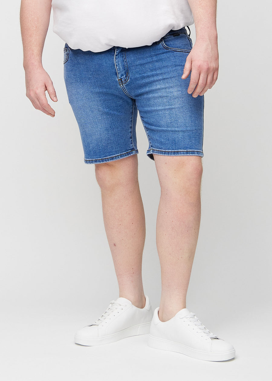 Denim middle-slim Shorts, die am Oberschenkel gerade sitzen und knapp über dem Knie enden, an einem Plus-Size-Model, von vorne gesehen.
