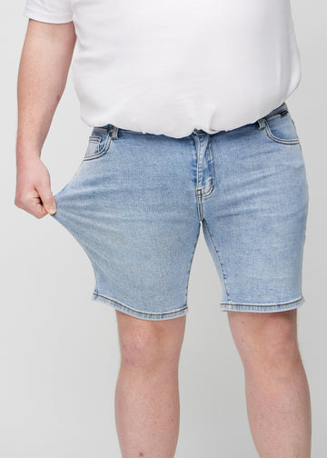 Das Plus-Size-Model zieht die Shorts am Oberschenkel auseinander, um den Stretch zu zeigen.