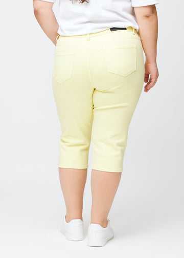 Lysegule slim capris set bagfra på en plus-size model – tydeligt billede af hele produktet og lommer.
