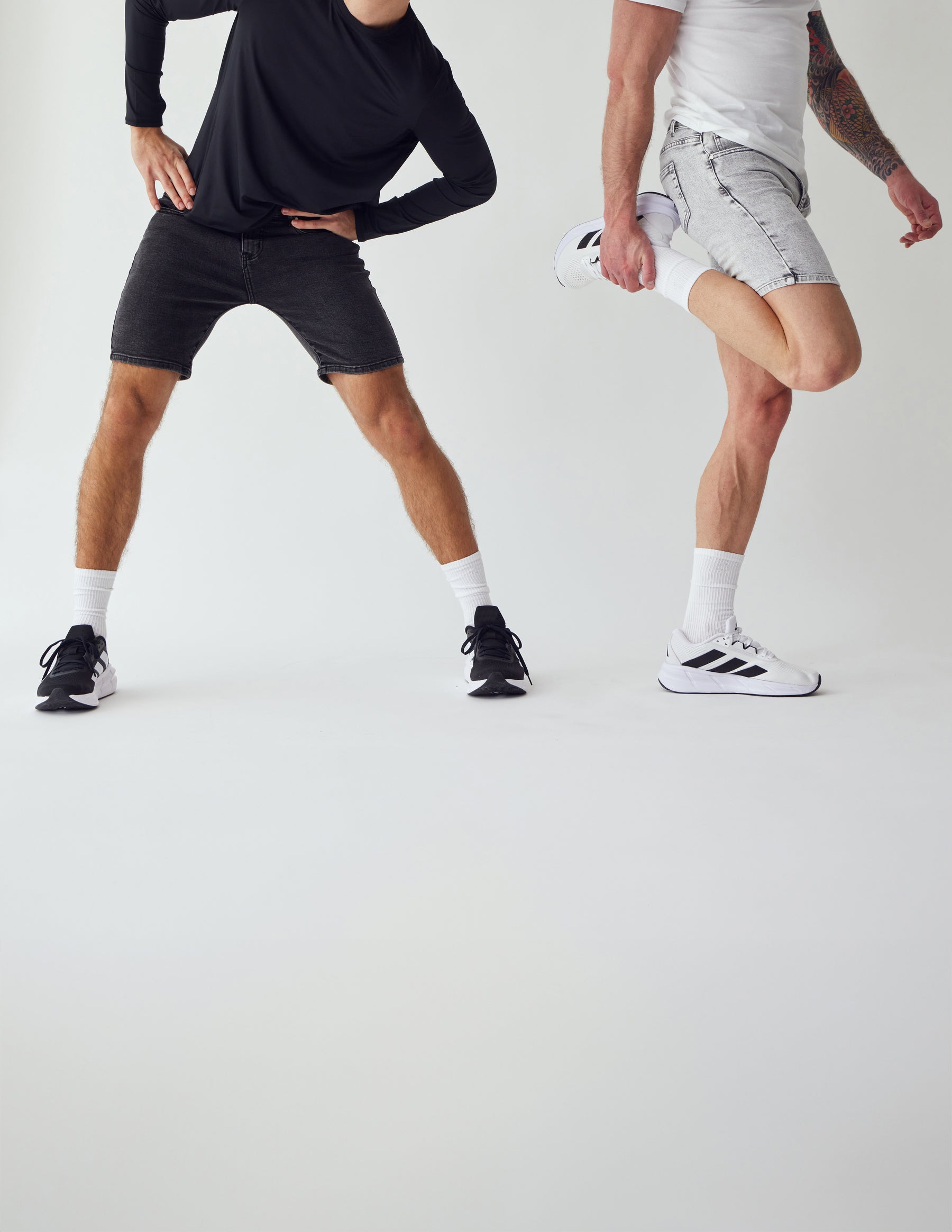 To mænd der strækker ud iført grå denim shorts 