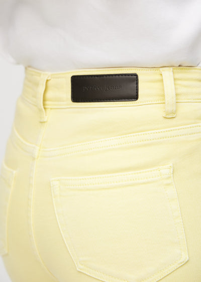 Baglommen på de lysegule slim capris – detaljebillede med fokus på logo og struktur.