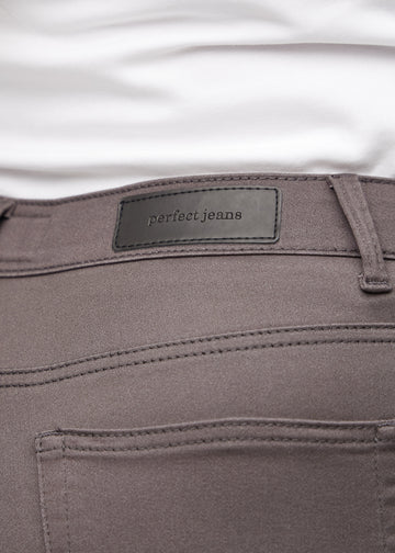 Baglommen på et par gråbrune loose jeans, hvor man kan se logoet på en plus-size model.