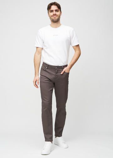 Model går ind i billedet, strækker i jeansene, viser dem frem ved at dreje rundt, og forlader derefter billedet.