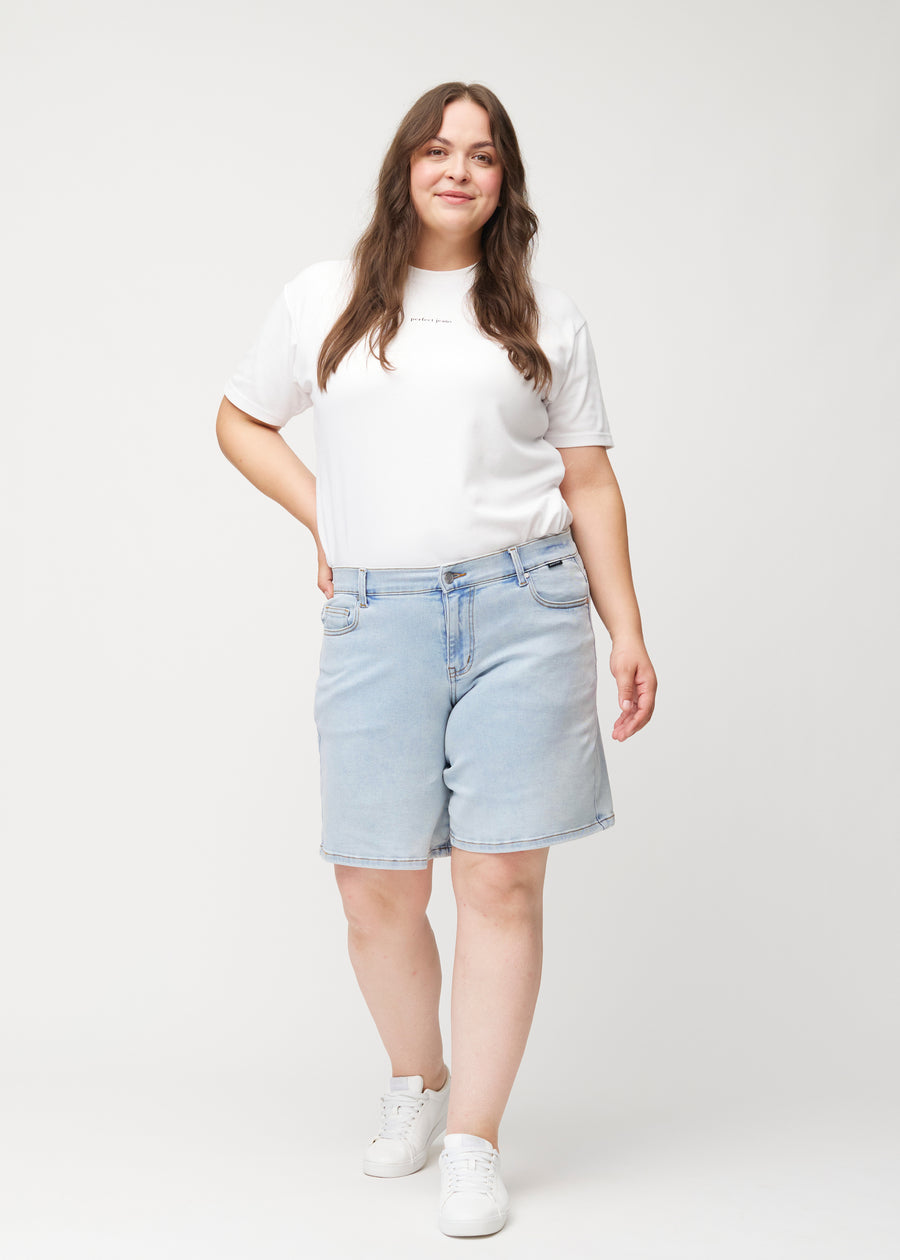 Damemodel viser lyseblå denimshorts til kvinder i farven Waves med middle waist og loose pasform i bevægelse.